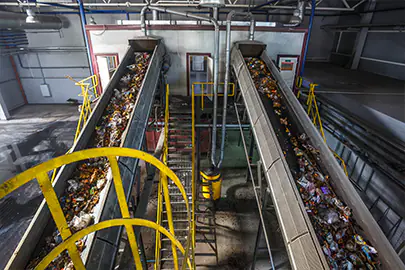 Blick von oben auf zwei große, parallele Förderbänder in einer industriellen Müllsortieranlage in Dresden, Sachsen, auf denen Abfälle und Wertstoffe zur Sortierung transportiert werden.